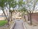 Backyard oasis featuring a paved walkway, mature trees, a trampoline, and custom hardscape at 1004 Windy Ferrell Ave, North Las Vegas, NV 89081