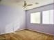 Bedroom with neutral carpet and lavender painted walls featuring ceiling fan and two windows at 1004 Windy Ferrell Ave, North Las Vegas, NV 89081