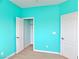Bedroom features aqua painted walls, neutral carpet, white trim, closet and an open door at 1004 Windy Ferrell Ave, North Las Vegas, NV 89081