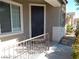 Inviting front entrance with a dark-colored door, convenient railing, and nice landscaping at 1004 Windy Ferrell Ave, North Las Vegas, NV 89081