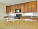 Close-up of kitchen island and granite countertops with cabinets, microwave and gas range stove at 1004 Windy Ferrell Ave, North Las Vegas, NV 89081