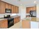 Functional kitchen layout with wood cabinets, stainless steel appliances, and a center island at 1004 Windy Ferrell Ave, North Las Vegas, NV 89081