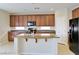 Bright kitchen features an island with granite countertop, stainless steel appliances and wooden cabinetry at 1004 Windy Ferrell Ave, North Las Vegas, NV 89081