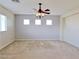 Spacious living room with neutral carpet, large windows, and a ceiling fan with lighting at 1004 Windy Ferrell Ave, North Las Vegas, NV 89081