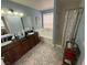 Bathroom featuring dual vanity sinks, tub and shower, and patterned tile at 10071 Lemon Valley Ave, Las Vegas, NV 89147