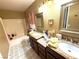 Bathroom featuring dual sinks with granite countertops, a tub, and coordinated decor at 10071 Lemon Valley Ave, Las Vegas, NV 89147