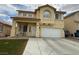 Two-story home with a tan exterior, white trim, two-car garage and a neatly kept lawn at 10071 Lemon Valley Ave, Las Vegas, NV 89147