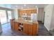 Bright kitchen features an island, oak cabinets, stainless steel appliances, and sliding glass doors to the backyard at 10071 Lemon Valley Ave, Las Vegas, NV 89147