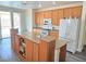 Bright kitchen features an island, oak cabinets, stainless steel appliances, and sliding glass doors to the backyard at 10071 Lemon Valley Ave, Las Vegas, NV 89147
