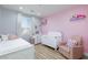 Charming bedroom in pink and gray colors and featuring a crib and comfortable furnishings at 10095 Ferton Lake Ave, Las Vegas, NV 89178