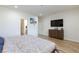 Bright bedroom with wood-look floors, dresser, and a tv mounted on the wall at 10095 Ferton Lake Ave, Las Vegas, NV 89178