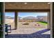 Spacious covered patio with pavers, perfect for outdoor dining and entertaining in a desert landscaped yard at 10095 Ferton Lake Ave, Las Vegas, NV 89178