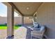 Covered patio features pavers, neutral color palette, and comfortable seating, creating a cozy outdoor space at 10095 Ferton Lake Ave, Las Vegas, NV 89178