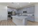 Kitchen boasts gray cabinets, granite countertops, stainless steel appliances, and center island at 10095 Ferton Lake Ave, Las Vegas, NV 89178