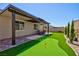 Backyard featuring a covered patio, putting green, and well-maintained landscaping perfect for outdoor living at 10251 Tiger Milkweed St, Las Vegas, NV 89141