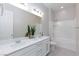 Bright bathroom featuring double sinks, white cabinets, a large mirror, and a shower-tub combination at 10251 Tiger Milkweed St, Las Vegas, NV 89141