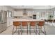 Modern kitchen with stainless steel appliances, white cabinets, and a large center island with seating at 10251 Tiger Milkweed St, Las Vegas, NV 89141