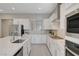 Modern kitchen with stainless steel appliances, white cabinets, and a large center island with sink at 10251 Tiger Milkweed St, Las Vegas, NV 89141