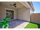 Covered patio area featuring brick pavers, artificial grass, and sliding glass door at 10251 Tiger Milkweed St, Las Vegas, NV 89141