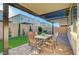 Inviting covered patio with dining set, manicured landscaping, and privacy, perfect for outdoor entertaining at 10251 Tiger Milkweed St, Las Vegas, NV 89141