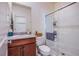 Bright bathroom featuring a single sink vanity, toilet, and glass-enclosed shower with built-in shelves at 104 Pollentia Ave, North Las Vegas, NV 89084