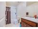 Cozy bathroom featuring a bathtub with shower, a toilet, and a single sink vanity with a dark wood cabinet at 104 Pollentia Ave, North Las Vegas, NV 89084