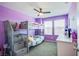 Vibrant purple bedroom featuring a bunk bed with stairs and a window that fills the room with natural light at 104 Pollentia Ave, North Las Vegas, NV 89084