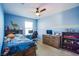Inviting blue bedroom with a comfortable bed, a ceiling fan, and natural light streaming through the window at 104 Pollentia Ave, North Las Vegas, NV 89084