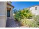 A covered front entrance with a brick walkway leading to a well-maintained garden at 104 Pollentia Ave, North Las Vegas, NV 89084