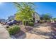 The front yard is landscaped with lush greenery and trees providing shade at 104 Pollentia Ave, North Las Vegas, NV 89084