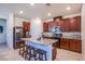 A modern kitchen with stainless steel appliances, granite countertops, and a kitchen island with barstool seating at 104 Pollentia Ave, North Las Vegas, NV 89084