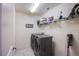 Functional laundry room featuring modern washer and dryer set and shelving for supplies at 104 Pollentia Ave, North Las Vegas, NV 89084