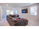 A spacious living room has a large sectional sofa with a view of the dining area and backyard at 104 Pollentia Ave, North Las Vegas, NV 89084