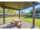 Shaded community picnic area with a table and benches, surrounded by green space and landscaping at 104 Pollentia Ave, North Las Vegas, NV 89084