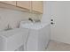 Bright laundry room featuring a utility sink, washer, dryer, and ample storage cabinets above at 10809 Clarion Ln, Las Vegas, NV 89134