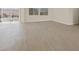 Open-concept living room with sliding glass doors leading to the backyard and light grey hard wood flooring at 10809 Clarion Ln, Las Vegas, NV 89134