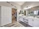 Bright bathroom featuring double sinks, a vanity area, and a walk-in closet for ample storage at 11143 Castellane Dr, Las Vegas, NV 89141