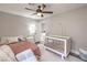 Bright bedroom featuring a white crib, ceiling fan, and inviting decor for a cozy and relaxing atmosphere at 11143 Castellane Dr, Las Vegas, NV 89141