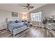 Serene main bedroom featuring a ceiling fan, a comfortable bed, and a cozy seating area by the window at 11143 Castellane Dr, Las Vegas, NV 89141