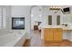 Bright bathroom features a soaking tub, fireplace, and wood cabinetry at 11369 Rancho Villa Verde Pl, Las Vegas, NV 89138