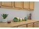 Close-up of oak cabinetry with plants and candles on the countertop at 11369 Rancho Villa Verde Pl, Las Vegas, NV 89138