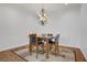 Elegant dining room featuring a modern chandelier and a stylish wooden table with four chairs at 11369 Rancho Villa Verde Pl, Las Vegas, NV 89138