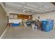 Garage with storage; overhead cabinets and open shelving above, and epoxy floors at 11369 Rancho Villa Verde Pl, Las Vegas, NV 89138