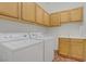 Well-equipped laundry room with washer, dryer, sink, and ample cabinet space at 11369 Rancho Villa Verde Pl, Las Vegas, NV 89138