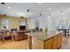 Spacious open floor plan with a stone fireplace that connects living and kitchen areas seamlessly at 11369 Rancho Villa Verde Pl, Las Vegas, NV 89138