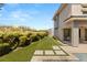 Expansive backyard featuring a manicured lawn, stone pavers, and access to the patio at 15 Gemstar Ln, Las Vegas, NV 89135