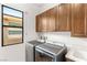 Functional laundry room with modern washer and dryer, ample cabinet space, and natural light at 15 Gemstar Ln, Las Vegas, NV 89135