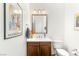 Elegant powder room featuring a modern vanity, framed mirror, and decorative artwork, creating a stylish and functional space at 15 Gemstar Ln, Las Vegas, NV 89135
