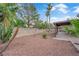 Wide backyard offering a covered patio, mature trees, and gravel landscaping, creating a peaceful outdoor space at 1913 Piccolo Way, Las Vegas, NV 89146