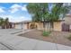 Single-story home featuring a two-car garage, mature shade tree, and arched entryway at 1913 Piccolo Way, Las Vegas, NV 89146